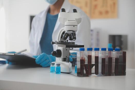 Professional lab. Amazing longhaired medical worker wearing uniform while using microscope during research photo