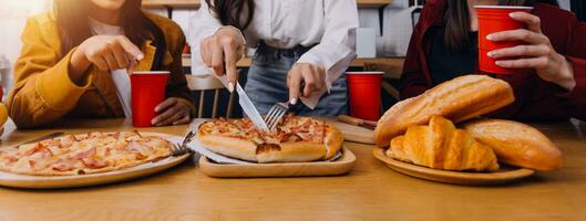 riendo grupo de diverso joven mujer colgando fuera a hogar juntos y comiendo pizzariendo grupo de diverso joven mujer colgando fuera a hogar comiendo Pizza foto