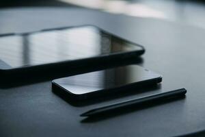 Open laptop with digital tablet and white smartphone. All with isolated screen on old wooden desk. photo