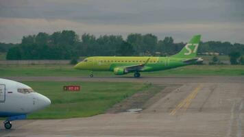 NOVOSIBIRSK, RUSSIAN FEDERATION JUNE 14, 2019 - Embraer E170 S7 VQ BYV accelerate before departure and Alrosa Boeing 737 taxiing on the apron after landing, early morning. video