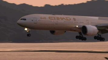 Phuket, Thaïlande novembre 26, 2019 - etihad Boeing 777 approchant et atterrissage sur le phuket aéroport contre le coucher du soleil ciel. vue de le Haut sol de le Hôtel près aéroport video