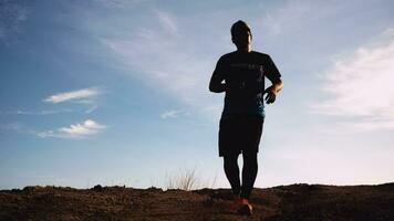 Slow motion. Men practice trail running in the evening. Silhouette of man running video