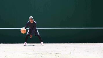 The concept of playing basketball and exercise. Asian man dribbling a basketball video