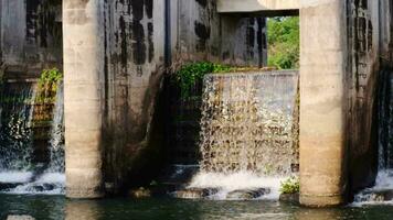 de concept van water beheer in de droog seizoen. water vloeiende van een klein dam poort in de platteland video