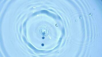 Slow motion of water droplets on refreshing blue water surface. video