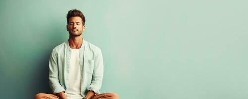 handsome man meditating on solid pastel background photo