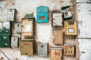 Old different mailboxs on the old wall photo