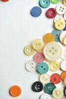 Multicolored buttons on a white background. Round buttons from clothes. photo