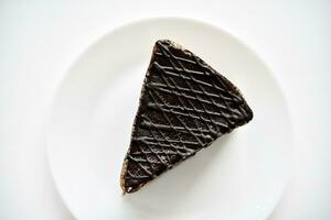 Chocolate cake on a white plate. A sweet snack. Sweetness for tea. photo