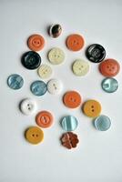 Multicolored buttons on a white background. Round buttons from clothes. photo