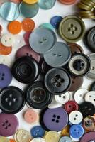 Multicolored buttons on a white background. Round buttons from clothes. photo