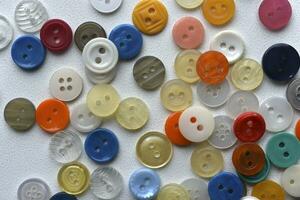 Multicolored buttons on a white background. Round buttons from clothes. photo