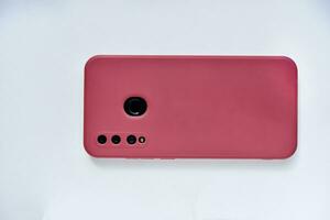 A smartphone in a red case on the back side. Phone camera. photo