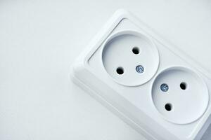 White double electrical outlet on a white background. Eurozette close-up. Electrical appliance. photo