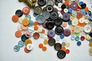 Multicolored buttons on a white background. Round buttons from clothes. photo