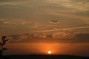 Beautiful summer sunset evening. Blue-yellow clouds of the setting sun. Sunset horizon. photo