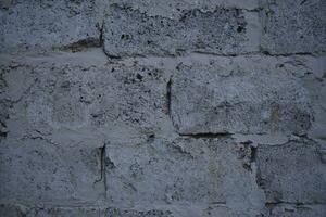 A gray wall of large blocks. Grey cinder block. The wall of an industrial building. photo