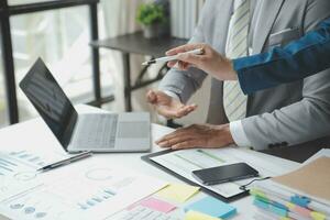 analyst or financial advisor provides advice on securities analysis and stock market management. Businessman showing documents through graphs and charts. Brainstorm and work together photo