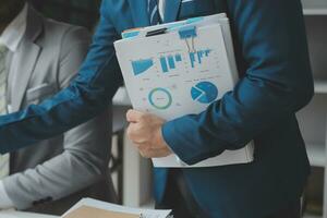 analyst or financial advisor provides advice on securities analysis and stock market management. Businessman showing documents through graphs and charts. Brainstorm and work together photo