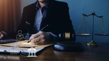 Justice and law concept.Male judge in a courtroom with the gavel, working with, computer and docking keyboard, eyeglasses, on table in morning light photo