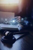 Justice and law concept.Male judge in a courtroom with the gavel, working with, computer and docking keyboard, eyeglasses, on table in morning light photo