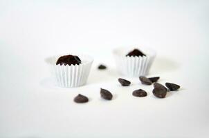Chocolate pills and pralines in paper wrappers isolated on white background with space for text photo