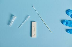 Flat lay composition of a covid-19 rapid antigen test on blue background photo