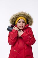 School-age traveler adventurer cute boy warming himself hugging thermos, shivering from cold looking at camera isolated on white background with copy space for ads. Winter leisure, holidays concept photo