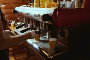 Closeup of unrecognizable barista making coffee in professional coffee machine photo
