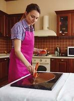 Confectioner cools a sweet chocolate on work marble surface for making handmade desserts photo