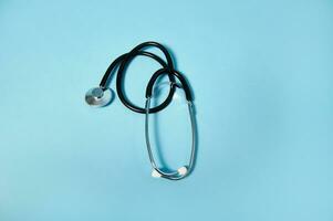 A stethoscope on blue background with soft shadow. Copy space photo