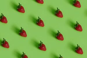 Colorful pattern of strawberries on green background with copy space photo