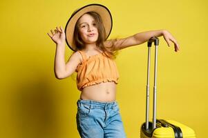 Mischievous cheery little child girl with suitcase, travelling abroad for summer vacations. Trip. Journey. Air flight photo