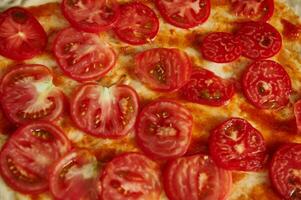 Close-up of tomatoes slices on pizza dough. Flat lay, top view, pattern photo