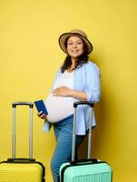 Happy pregnant woman stroking belly, traveling abroad during pregnancy, smiling at camera, isolated yellow background photo