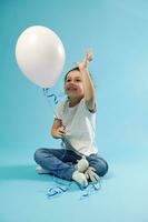 Beautiful little girl playing with a pink balloon in her hand expressing happiness. Concept of Children Protection Day. photo