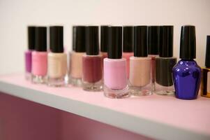 Jars of nail polish of different colors on the shelf photo