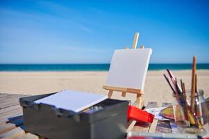 Easel with canvas on the sea background. Concepts of art, hobby and painting in open air photo