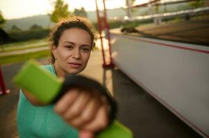 atractivo deportista hacer ejercicio en el temprano mañana, haciendo un cardio formación utilizando pesas para boxeo en el campo deportivo foto