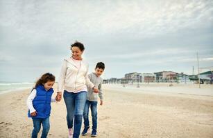 Happy mother with her children walking on the beach. Happy family concept. Happy motherhood concept. Happy mother's Day photo