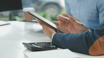 Financial analysts analyze business financial reports on a digital tablet planning investment project during a discussion at a meeting of corporate showing the results of their successful teamwork. video