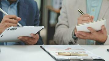 Financial analysts analyze business financial reports on a digital tablet planning investment project during a discussion at a meeting of corporate showing the results of their successful teamwork. video