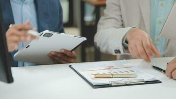 Financial analysts analyze business financial reports on a digital tablet planning investment project during a discussion at a meeting of corporate showing the results of their successful teamwork. video