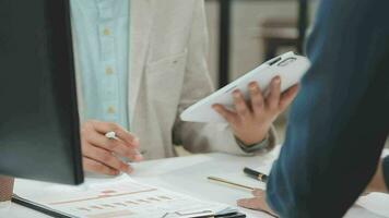 Financial analysts analyze business financial reports on a digital tablet planning investment project during a discussion at a meeting of corporate showing the results of their successful teamwork. video