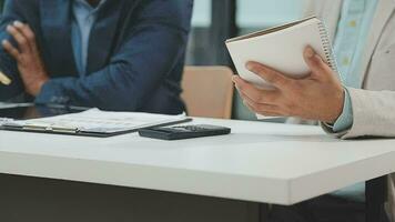 Financial analysts analyze business financial reports on a digital tablet planning investment project during a discussion at a meeting of corporate showing the results of their successful teamwork. video