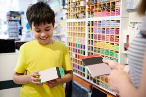 hermoso adolescente colegial sonrisas en general, disfruta compras en papelería almacenar. creativo gente. pasatiempo. multa Arte. educación foto