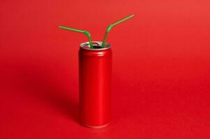 A studio shot with a soft shadow of a red metal can with the ring pul and two green straws on a red background. Green-Red, color contrast photo