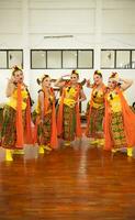 a group of traditional Javanese dancers having fun with their friends on stage after the performance ended photo