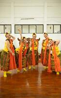 un grupo de tradicional javanés bailarines teniendo divertido con su amigos en etapa después el actuación terminó foto