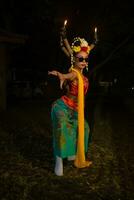 a Javanese dancer dances very skillfully while wearing sunglasses on her eyes and very beautiful facial makeup photo